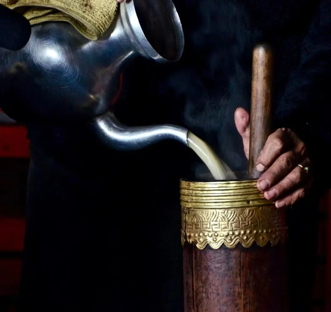 Pouring tea into a traditional churn
