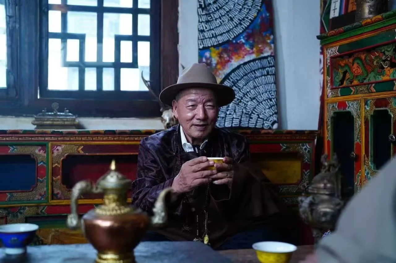 An elder drinking Tibetan tea in a painted plateau home